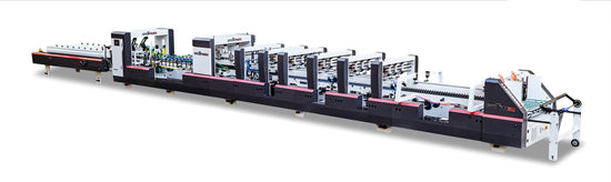 Long industrial folder gluer machine with multiple processing stations for carton production.